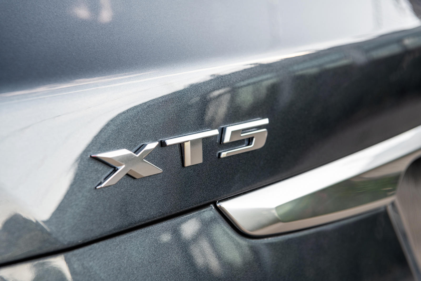 A close up of the XT5 badge on a Cadillac.