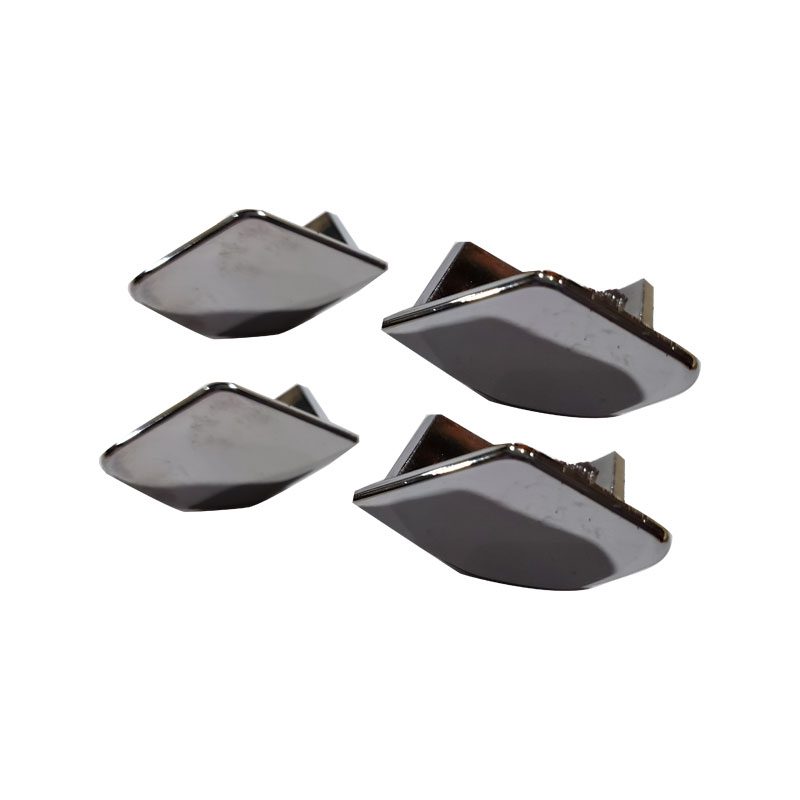 Four shiny metallic corner protectors for furniture or boxes.