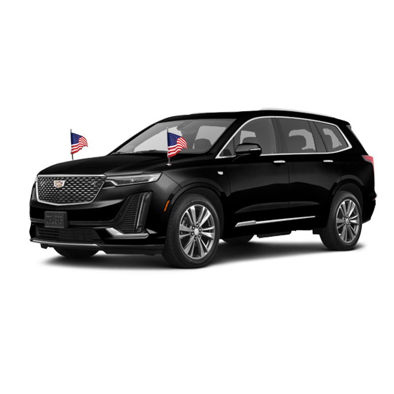Black Cadillac SUV with two small American flags on the hood.
