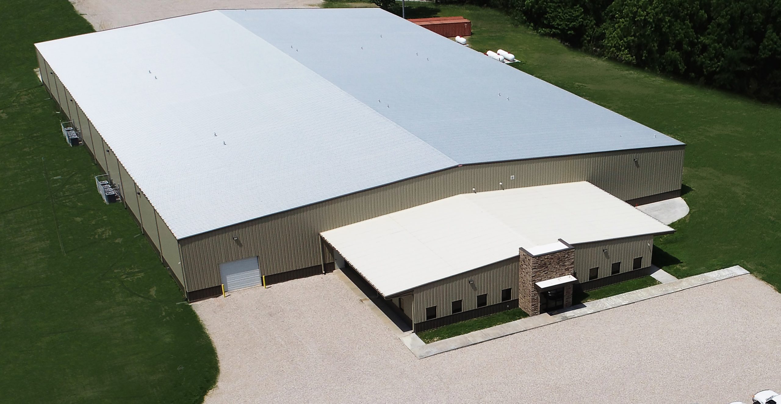 A large industrial warehouse with a smaller office section in front.