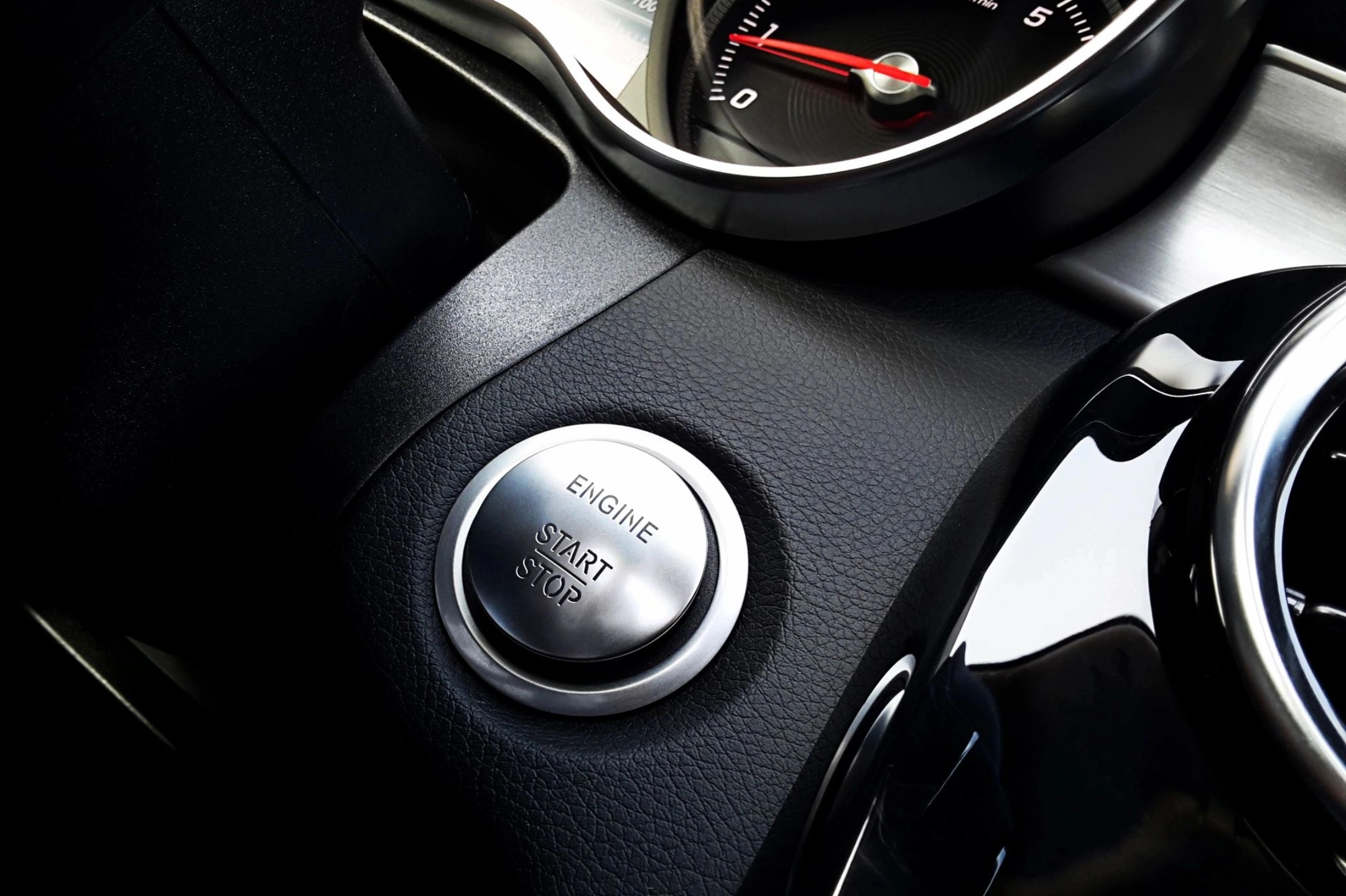 Close-up of a car's engine start/stop button.