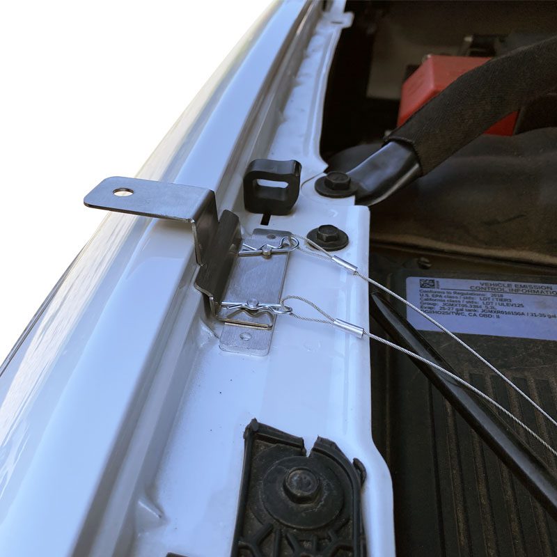 Close-up of a white vehicle door hinge and lock mechanism.
