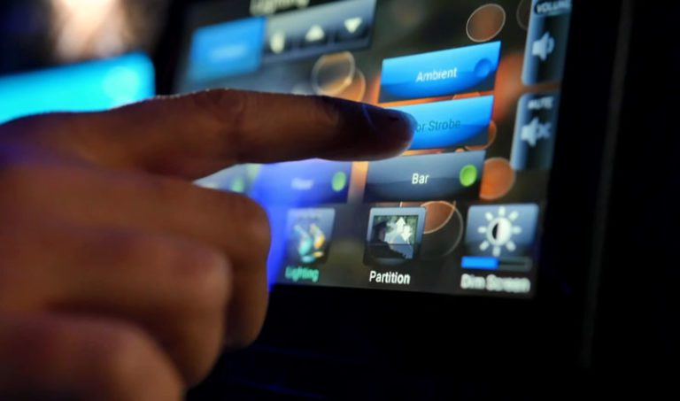 Finger interacting with a touchscreen interface displaying various icons.