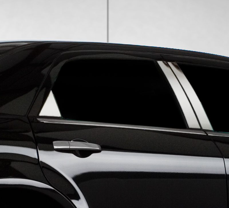 Close-up of a black car's rear door with tinted windows and chrome handle.