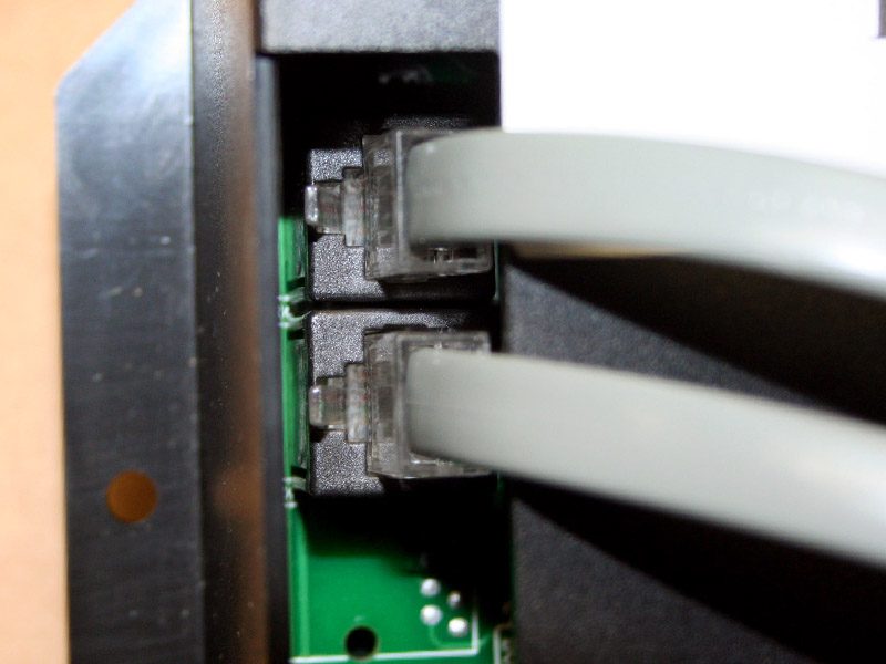 Two gray ethernet cables plugged into a circuit board.
