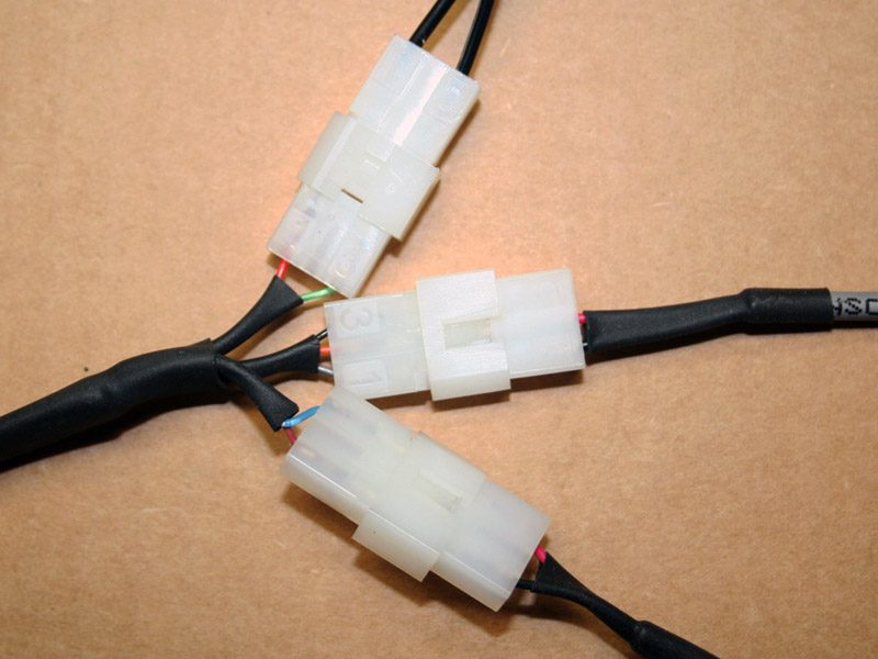Close-up of white electrical connectors linking black wires.