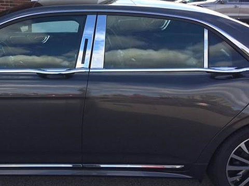 Side view of a sleek black luxury car with tinted windows and chrome accents.