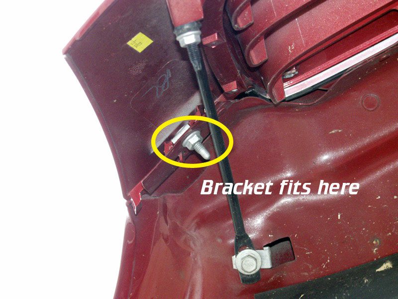 Close-up of a vehicle hood hinge and bracket installation.
