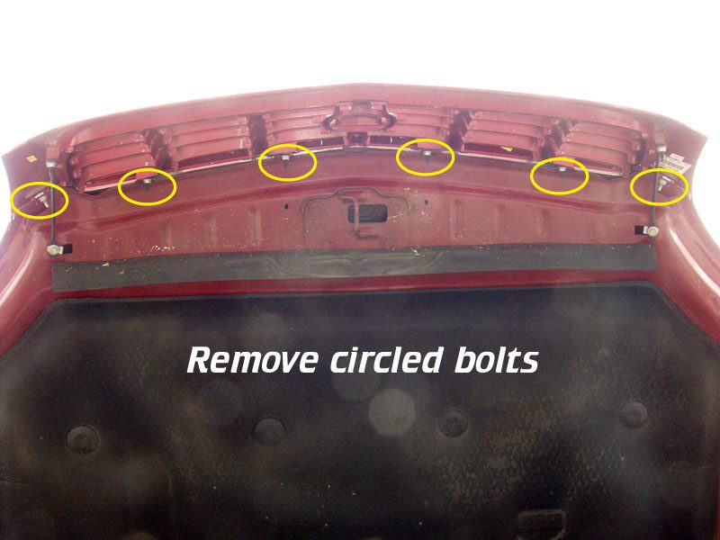 Close-up of a part with four bolts circled for removal.