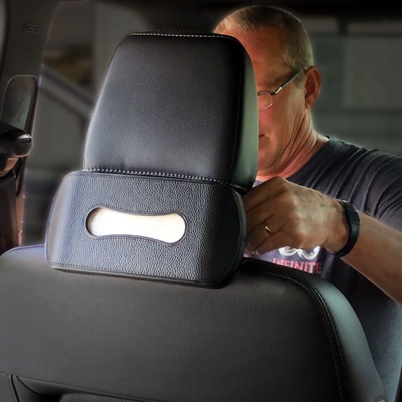Man adjusting headrest in a car.