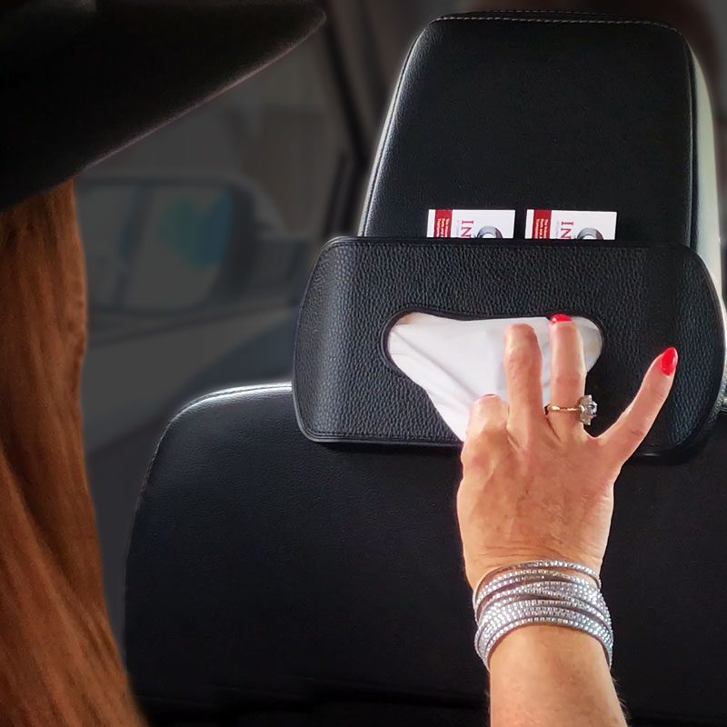 Person cleaning a car headrest with a wipe.
